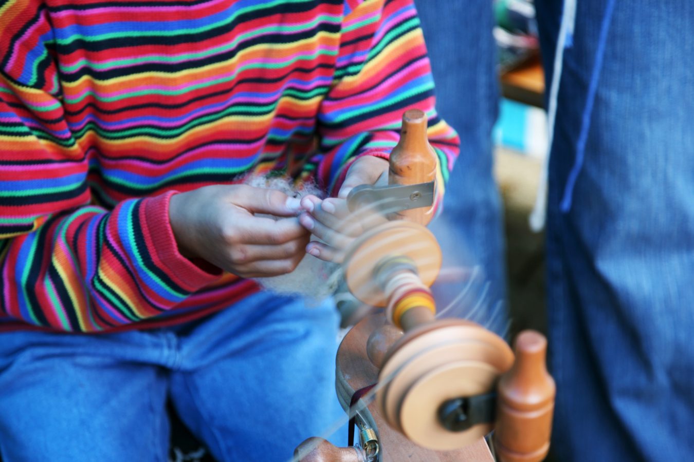 Et barn på jobb spinner garn. Bevegelsesuskarphet på rokk. Foto: Istock