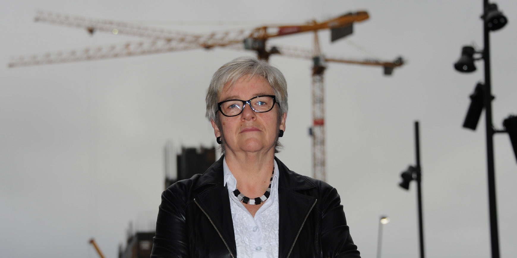 YS-leder Jorunn Berland uttaler segt om bemanningsbransjen. Bak henne skimter vi flere av heisekranene i Bjørvika.