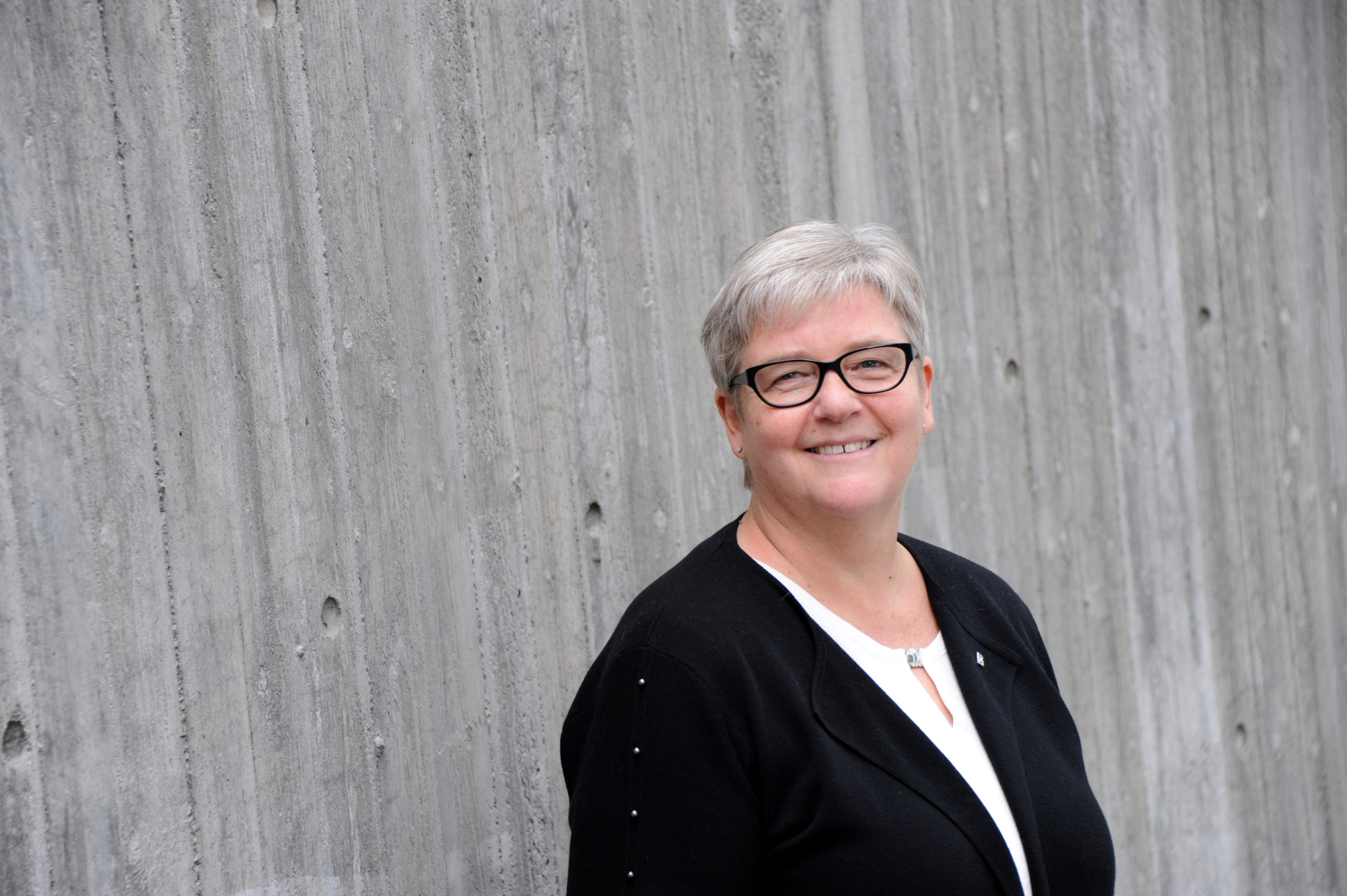 YS-leder JOrunn ebrland mot grå murvegg.