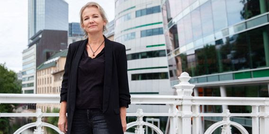 Forhandlingsleder for Yrkestrafikkforbundet Linda Jæger står på en bro med bygningner bak seg. 
