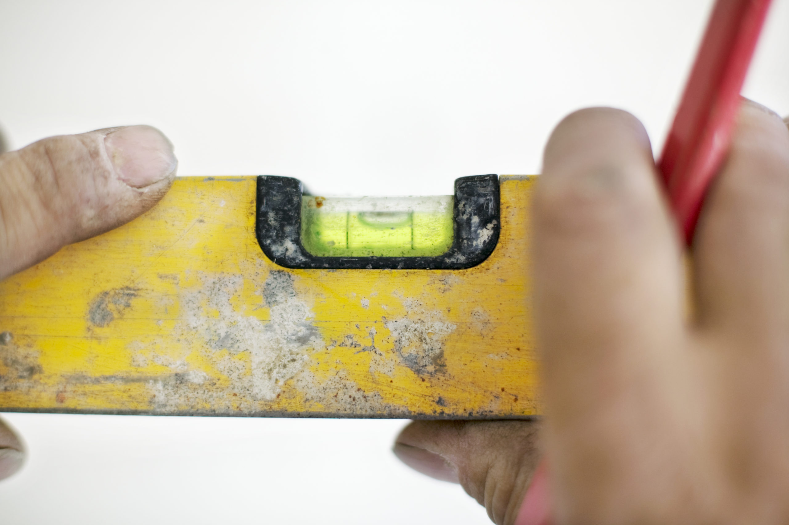 To hender med rød blyant holder gult vater