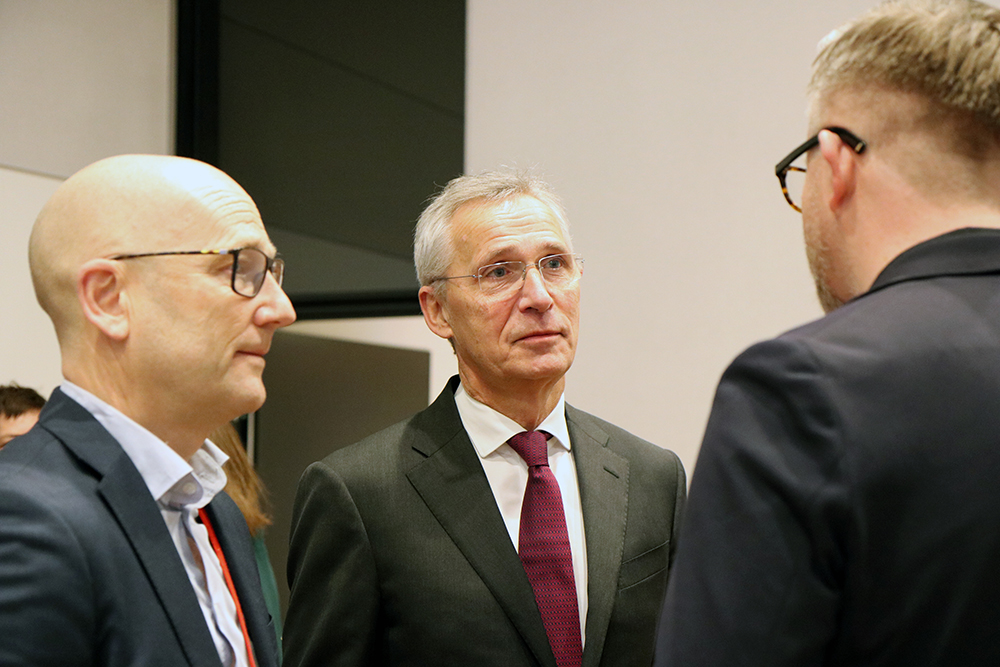 Samtale mellom NHO-lederen, finansministeren. YS-lederen står med ryggen til.