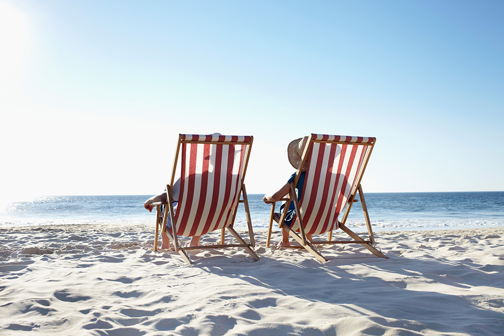 2 mennesker sitter i strandstoler på en strand